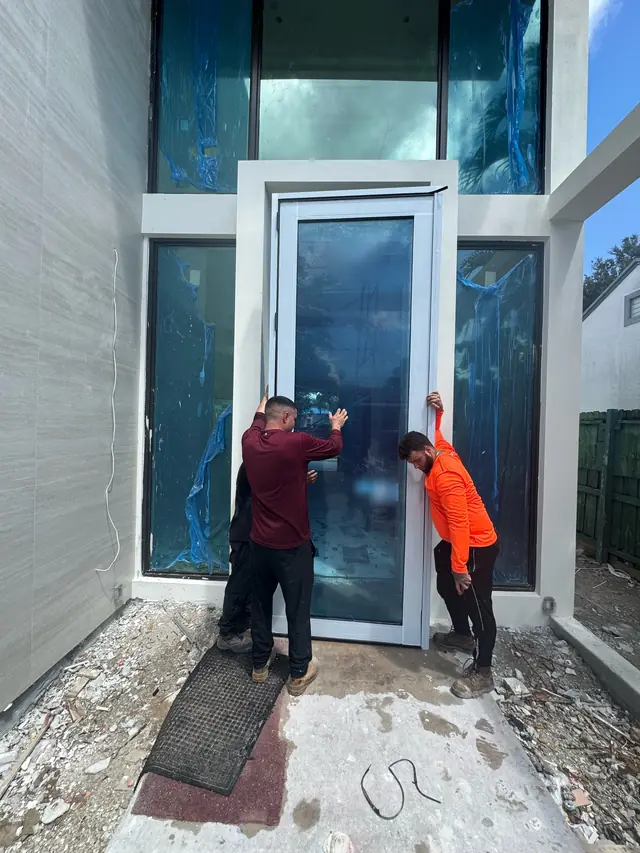 Mora Glass Windows installers setting an impact door