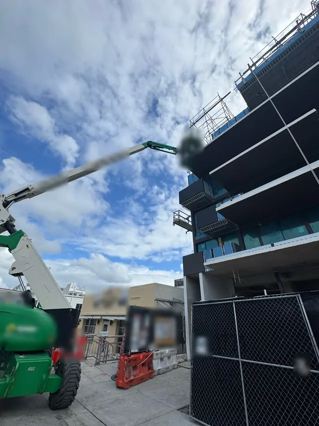 Commercial project using a lift to install impact windows at height